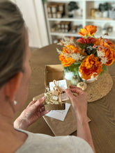 Load image into Gallery viewer, Sue holding a small box with a car diffuser inside.