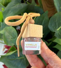 Load image into Gallery viewer, Mini glass jar with wooden lid as a car diffuser in the scent of "Vanilla Peppermint" in front of greenery.