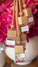 Load image into Gallery viewer, Car Diffusers from the Spring and Summer Collection hanging in front of pink peonies.