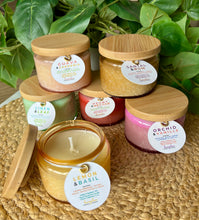 Load image into Gallery viewer, A Group of the colorful, 4 oz embossed jar candles from Bungalow's Classic Collection stacked and one open to see wick