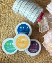 Load image into Gallery viewer, Travel candles stacked in front of a packaged bundle on a woven mat.