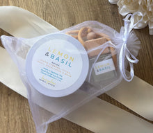 Load image into Gallery viewer, A car diffuser and 4oz mini candle in the Lemon & Basil scent, bundled together in a white mesh drawstring bag.
