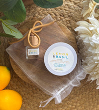 Load image into Gallery viewer, A car diffuser and 4oz mini candle in the Lemon & Basil scent, set on top of a white mesh drawstring bag that it will be bundled in.