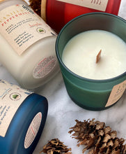 Load image into Gallery viewer, Winter and Holiday Scented Candles in colorful frosted jars showing the crackling wood wick.