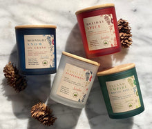 Load image into Gallery viewer, The 4 Holiday Candle Scents that come in a frosted, colored jar posed together.