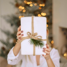 Load image into Gallery viewer, A woman holding up a wrapped gift.