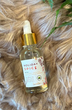 Load image into Gallery viewer, Bottle of Holiday Spice diffuser oil on a textured surface with green leaves.
