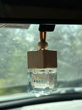 Load image into Gallery viewer, A Bungalow car diffuser in the Lemon & Basil scent hanging from the car rearview mirror.