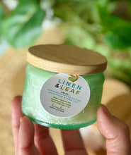 Load image into Gallery viewer, The Linen & Leaf scent from Bungalow's Classic Collection shown in the cute 4oz green-colored embossed jar.