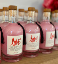 Load image into Gallery viewer, A row of recyclable glass apothecary jars of LOVE Luxe Bubble Bath with a wood cork stopper, containing pink bubble bath. The label has the brand name 'LOVE' written in a decorative font, and the product is part of the Valentine's & Mother's Day Collection.
