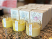 Load image into Gallery viewer, Three candles without lids in front of lines of boxes with each respective scent