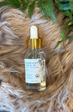 Load image into Gallery viewer, Bottle of Midnight Snow on Grand diffuser oil on a textured surface with green leaves.