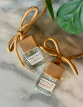 Load image into Gallery viewer, Two small car diffuser bottles with wooden caps in the scent of Post Falls Cottonwood Reserve, lying on a marble surface.