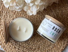 Load image into Gallery viewer, Large candle labeled 'Rock Away' on a woven surface with flowers.