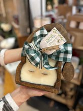 Load image into Gallery viewer, A hand-carved wood dough bowl candle in the shape of a Santa hat with a checkered green and black ribbon.