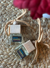 Load image into Gallery viewer, Car air freshener in a mini jar and wooden lid with 'Snow Country' scent on a woven surface.