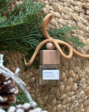 Load image into Gallery viewer, Mini glass jar with wooden lid as a car diffuser in the scent of "Spokane Winter Wanderlust" in front of greenery.