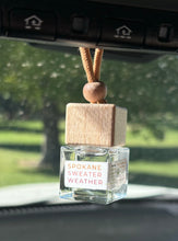 Load image into Gallery viewer, A car diffuser in the Spokane Sweater Weather scent from the Fall Candle Scent Collection hangs from the car rearview mirror.