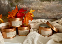 Load image into Gallery viewer, A group of the Spokane Sweater Weather Travel Tin Candles stacked on top of each other.