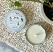 Load image into Gallery viewer, Mini travel candle in a white metal tin in Trails of Mount Spokane Scent.
