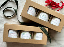 Load image into Gallery viewer, Two cardboard gift boxes with open windows, displaying multiple 3 candles inside. The boxes are presented on a white fabric surface with a green ribbon to the side.