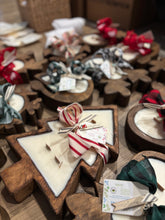 Load image into Gallery viewer, Wooden Dough Bowl candles in decorative shapes like trees and snowmen, tied with decorative ribbon on a wooden surface