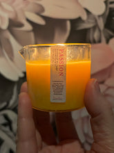 Load image into Gallery viewer, massage candle lit and being held up in front of floral graphic
