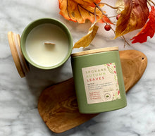 Load image into Gallery viewer, The Spokane Autumn Leaves scent from the Fall Candle Collection is shown in a beautiful sage green colored ceramic jar.