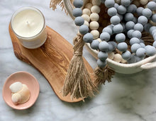 Load image into Gallery viewer, A basket full of Mango Wood Contentment Bead strings in gray and natural.