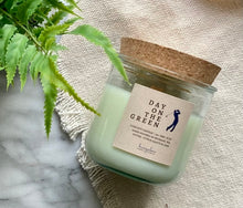 Load image into Gallery viewer, The scent, Day on the Green, from the Golf Collection is shown in the 8oz candle in glass jar with cork lid.