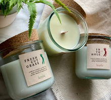 Load image into Gallery viewer, Candles from the Golf Collection are grouped together with one lid off to show wood wick.