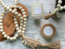 Load image into Gallery viewer, Natural Mango Wood Contentment Bead with Jute Tassels stage with candles and a wine bottle