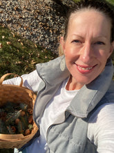 Load image into Gallery viewer, Sue holding a basket of pinecones and sprigs she has collected