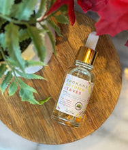 Load image into Gallery viewer, Bottle with dropper lid of 'Spokane Autumn Leaves' scented fragrance oil on a wooden surface with flowers in the background

