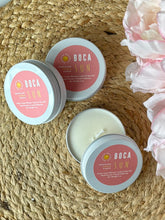 Load image into Gallery viewer, Three travel candle tins with a pink label in the Boca Sun scent on a woven surface with flowers.
