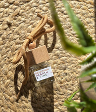 Load image into Gallery viewer, Car air freshener with &#39;Deer Park Hearth &amp; Pine&#39; label on a woven surface

