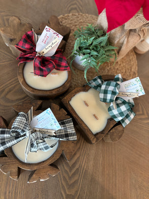 3 Wood Dough Bowl Candles tied with holiday bows and grouped together on a table.