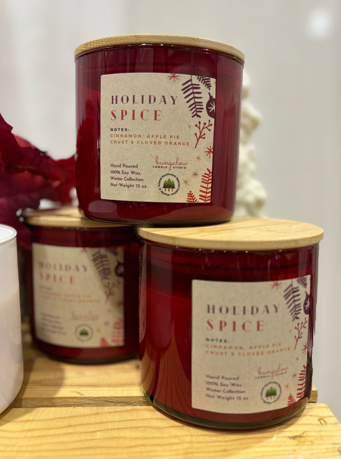 3 Holiday Spice Scented candles in red jars stacked on a table