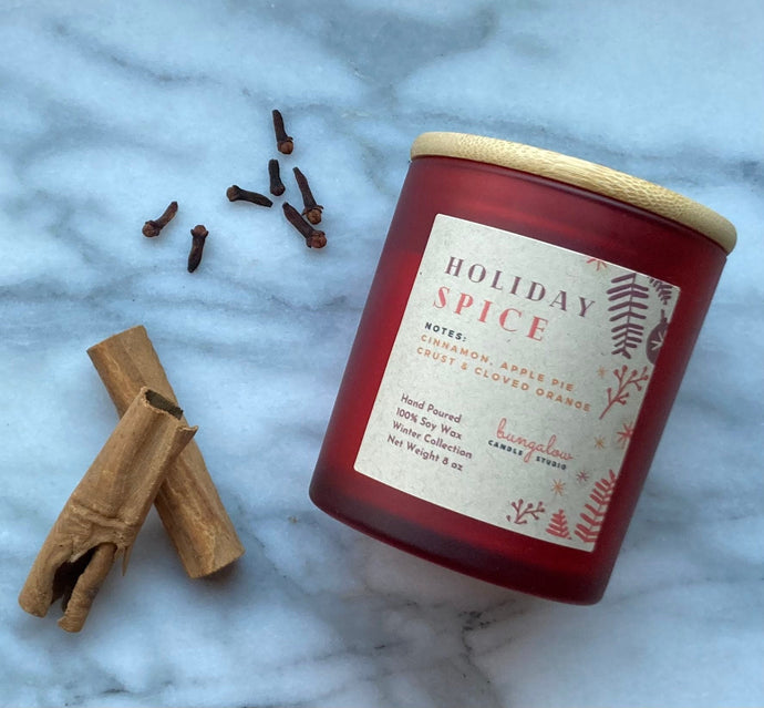 Holiday Spice Bungalow Candle in frosted red jar with wooden lid.