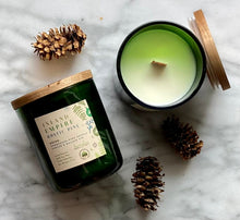 Load image into Gallery viewer, The wood wick on Bungalow&#39;s Inland Empire Rustic Pine Holiday Candle in a frosted green jar.

