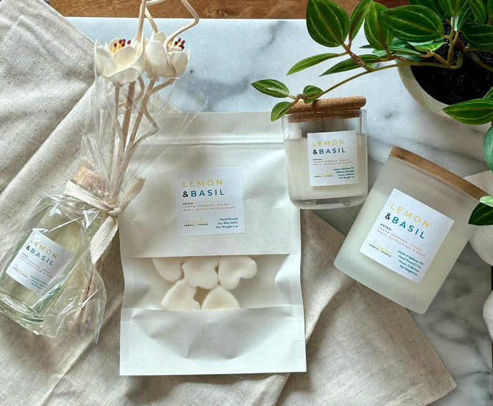 Flat lay of four Bungalow products in the Lemon & Basil scent: 8 oz candle, mini candle, wax melts, and a wood reed diffuser.