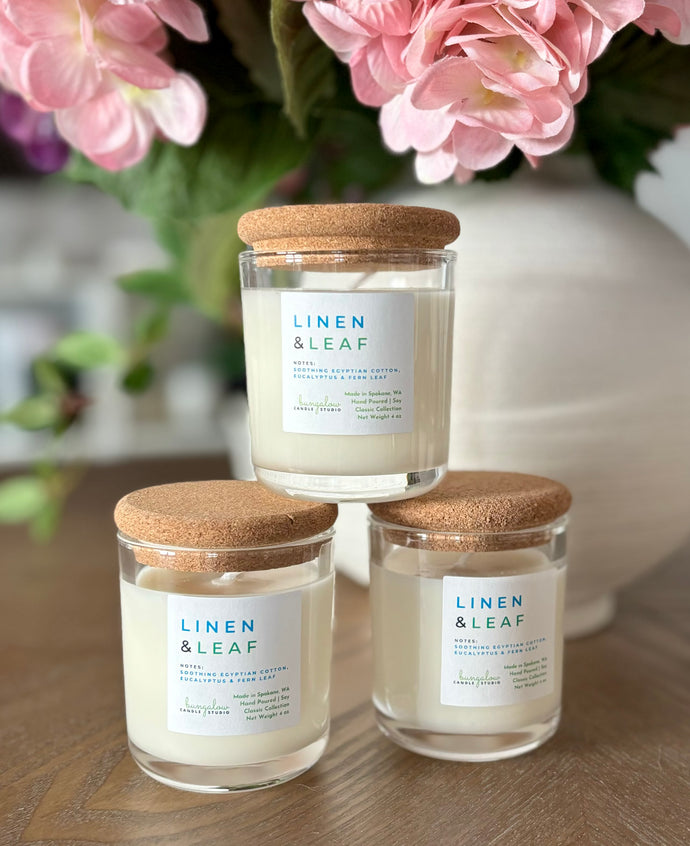 3 Linen & Leaf mini 4 oz candles from the Classic Collection stacked on top of each other.