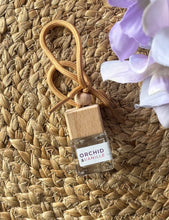 Load image into Gallery viewer, A Bungalow car diffuser in the Orchid &amp; Banillen scent on a woven mat.
