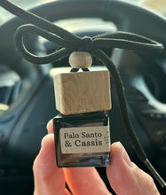 Load image into Gallery viewer, The Palo Santo &amp; Cassis scent from the Cascade Collection in a car diffuser.
