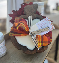 Load image into Gallery viewer, Decorative pumpkin-shaped wood dough bowl tied in a fall plaid bow on a wooden table.
