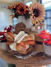 Load image into Gallery viewer, Decorative fall arrangement with a pumpkin-shaped wood dough bowl tied in a plaid bow on a wooden table
