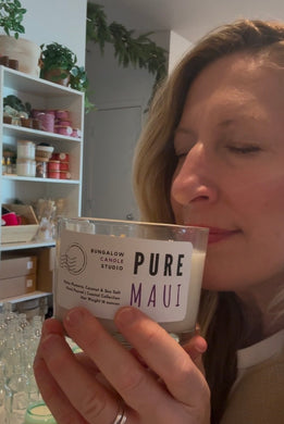 The Pure Maui Scent from the Coastal Collection is shown in the 16 oz size. Sue, owner is smelling it.