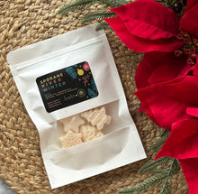 Load image into Gallery viewer, A white pouch of soy wax melts in the Spokane River Winter scent laying flat on a woven mat.
