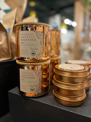 The Signature Spokane Sweater Weather in Rose Gold jars and tins is shown stacked together in the large 16oz jar and smaller travel tins.