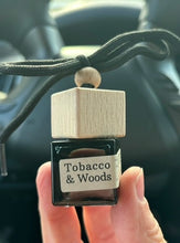 Load image into Gallery viewer, The Tobacco &amp; Woods scent from the Cascade Collection in a car diffuser.
